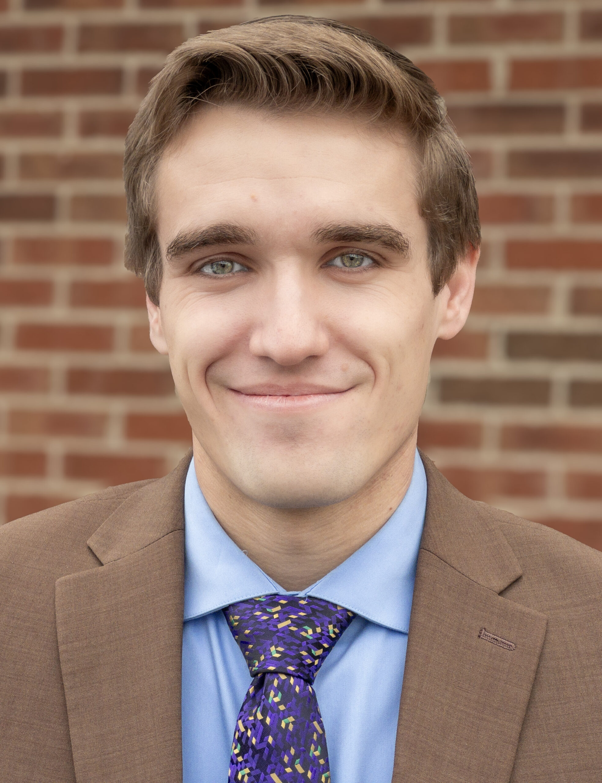 Dylan Davis Attorney at Law CELO Lillington NC serving Harnett and Lee Counties - Headshot with tan suit and blue shirt.